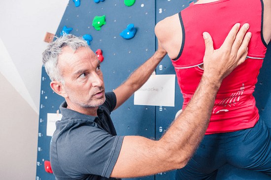 Therapeut mit der Hand am Rücken der Patientin, im Blickkontakt