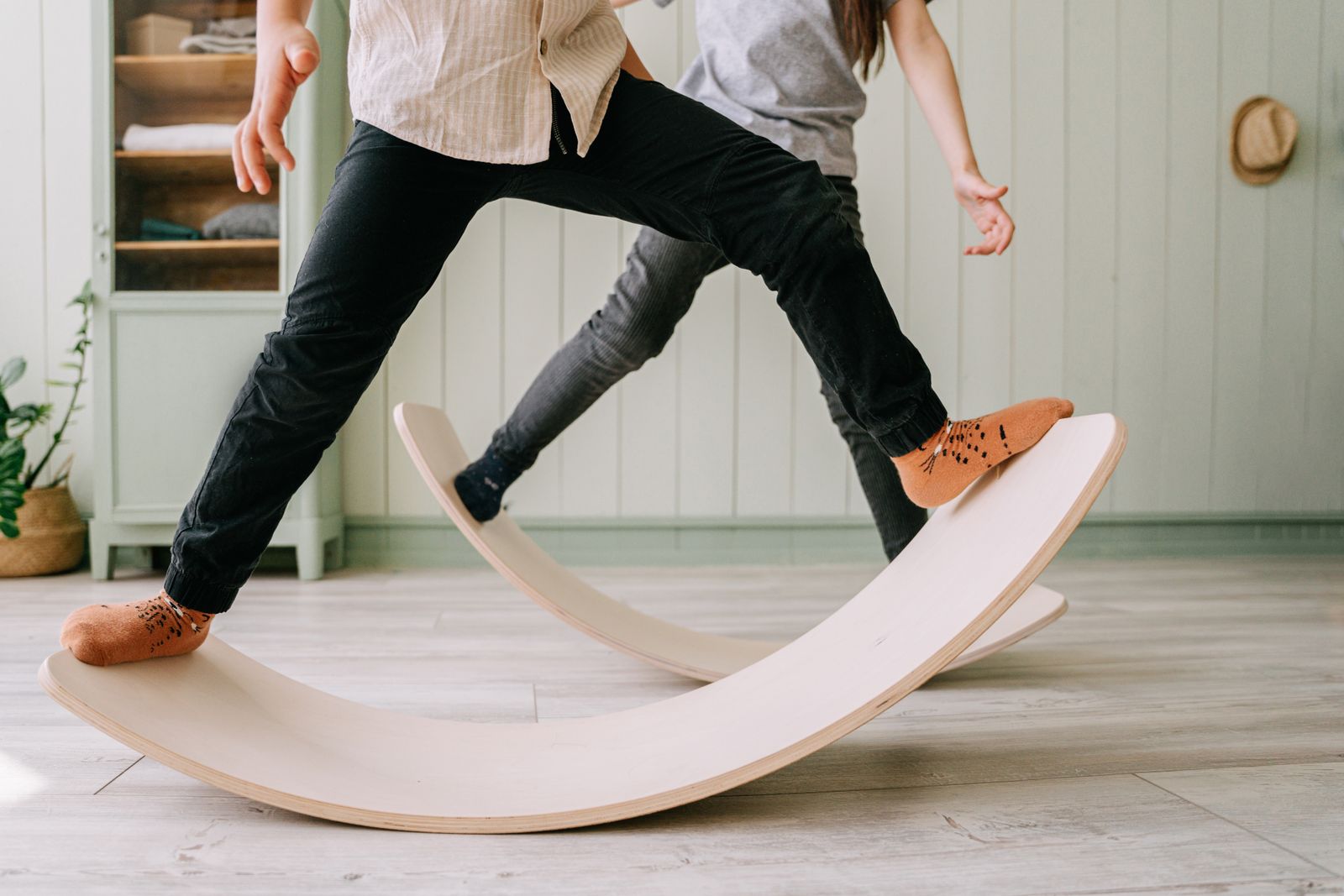 Zwei Kinder spielerisch auf Holz-Balanceboards