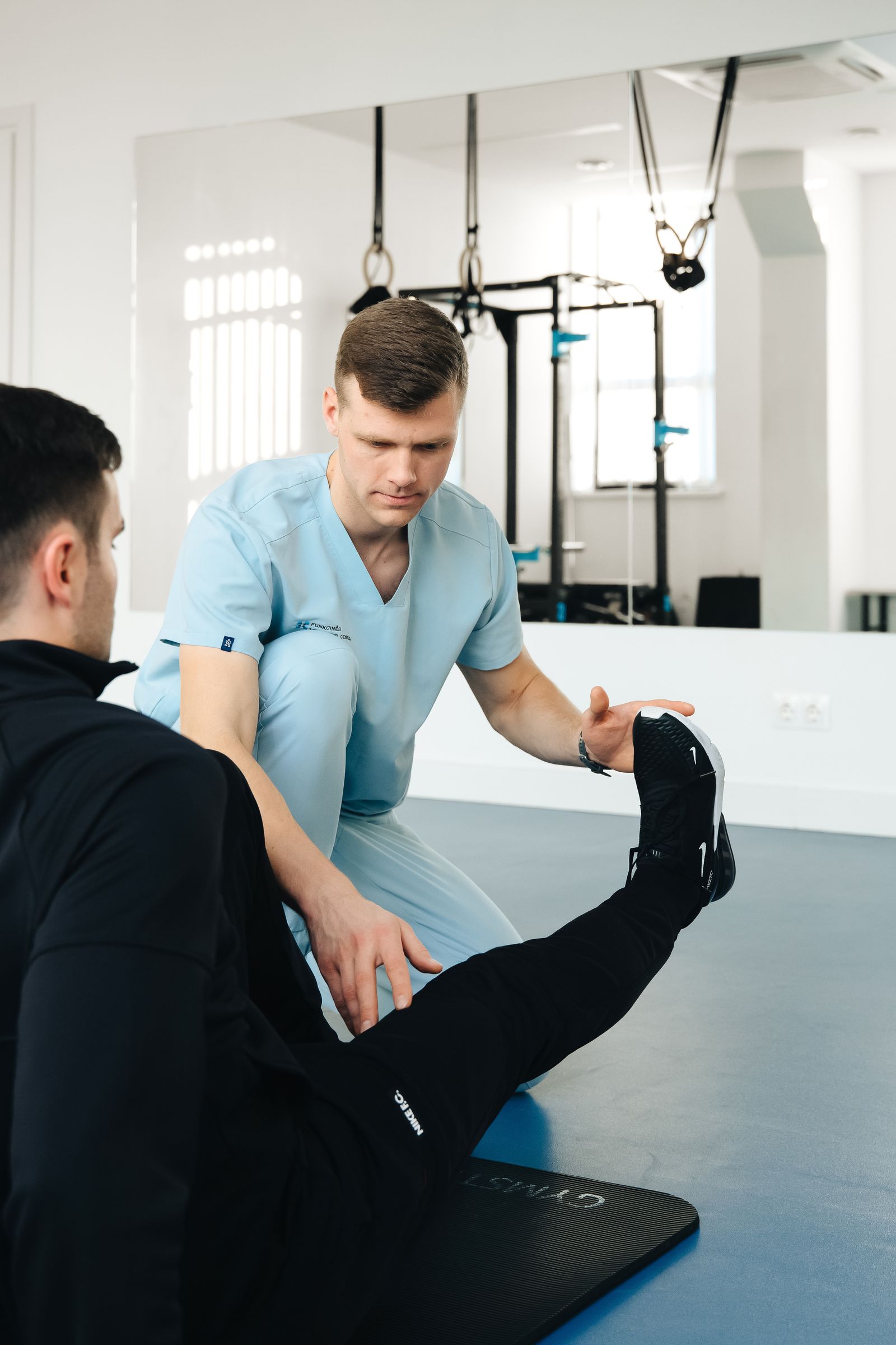 Physiotherapeut begleitet einen Patienten bei einer Gleichgewichtsübung in einer modernen Praxis