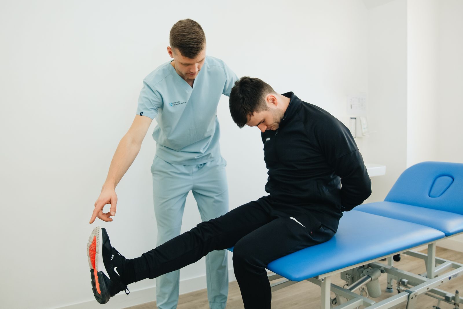 Physiotherapeut instruiert einen Patienten bei einer Reha-Übung
